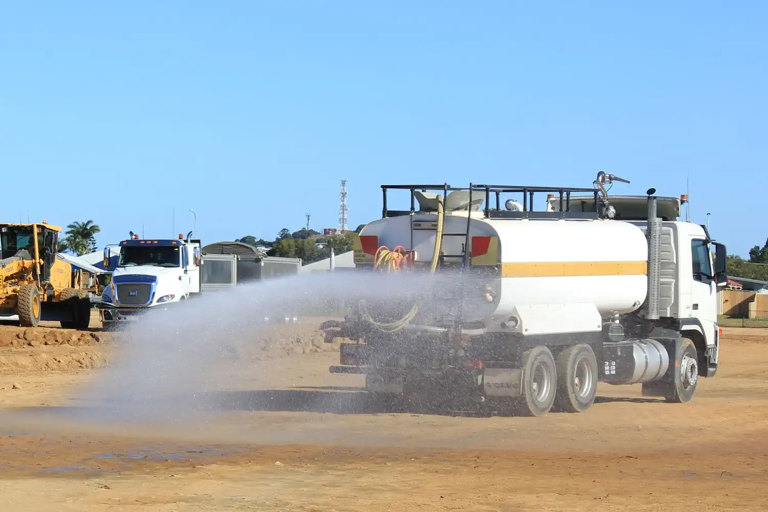 Water tanker truck spraying dust suppressant on a haul road