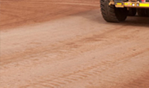 Heavy vehicle wheel on treated dirt road