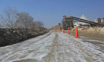 Industrial plant access road with dust control